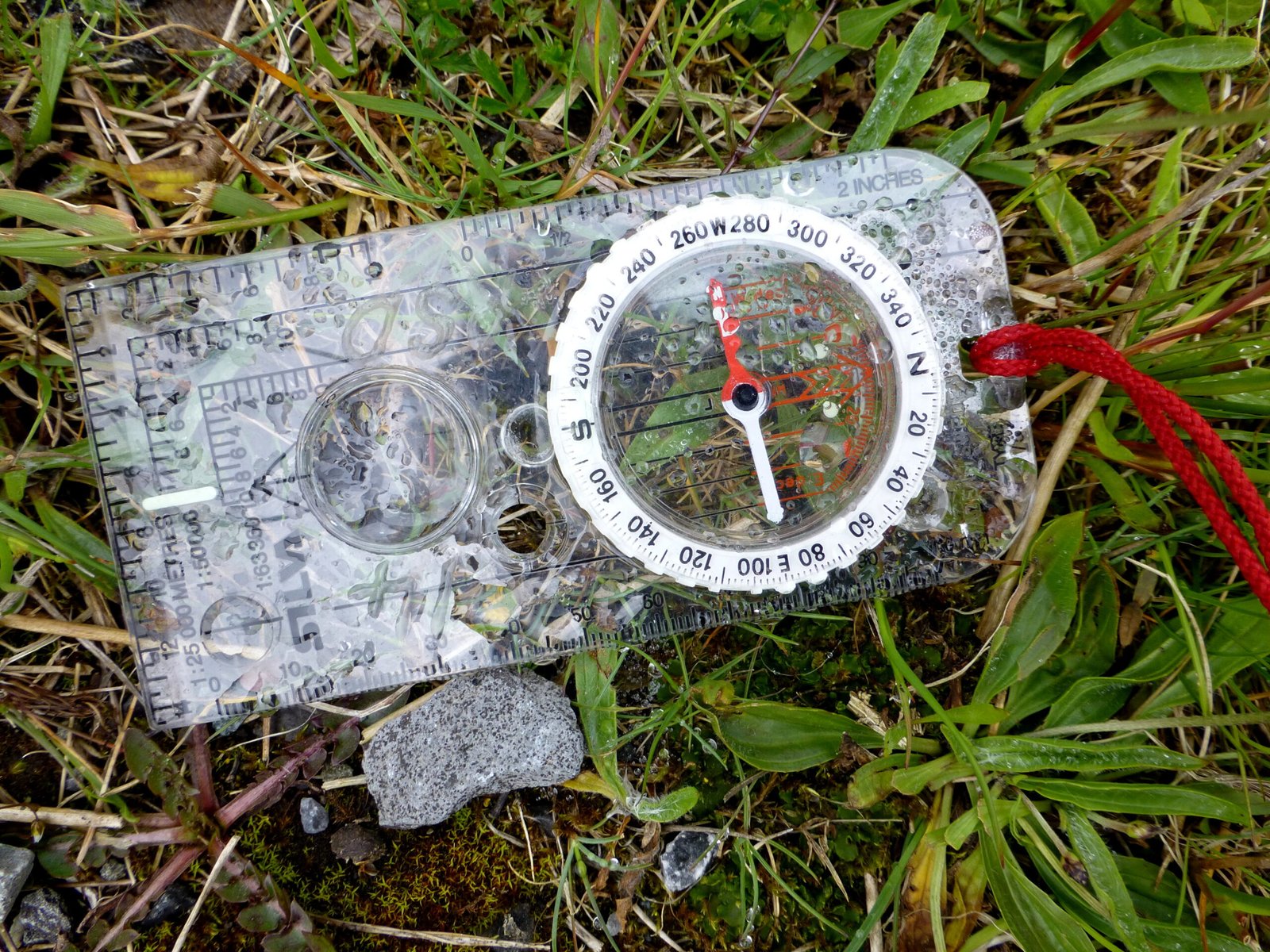 Boussole de randonneur tenue en main, hors sentier balisé